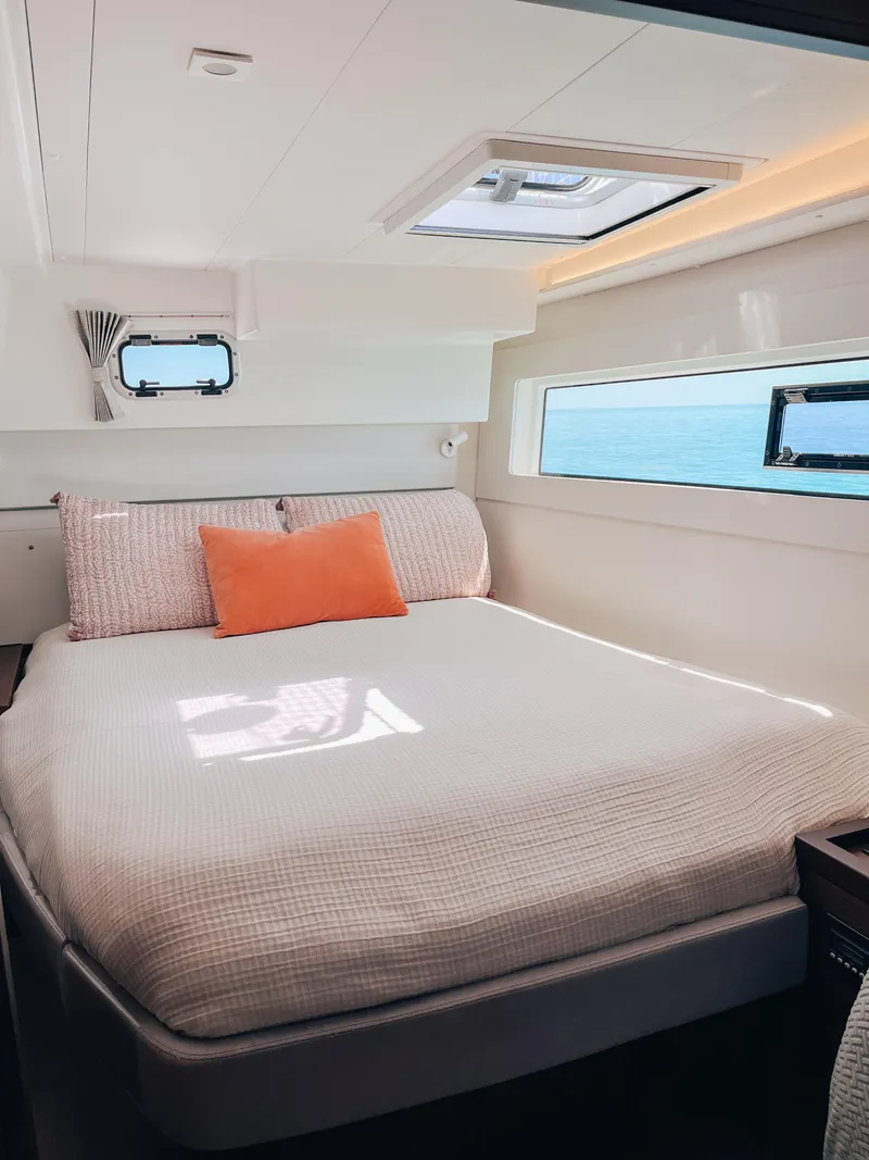 Slide: The Image of 2023 Lagoon 40 yacht cabin with cozy bed, ocean view, and modern design. - 26