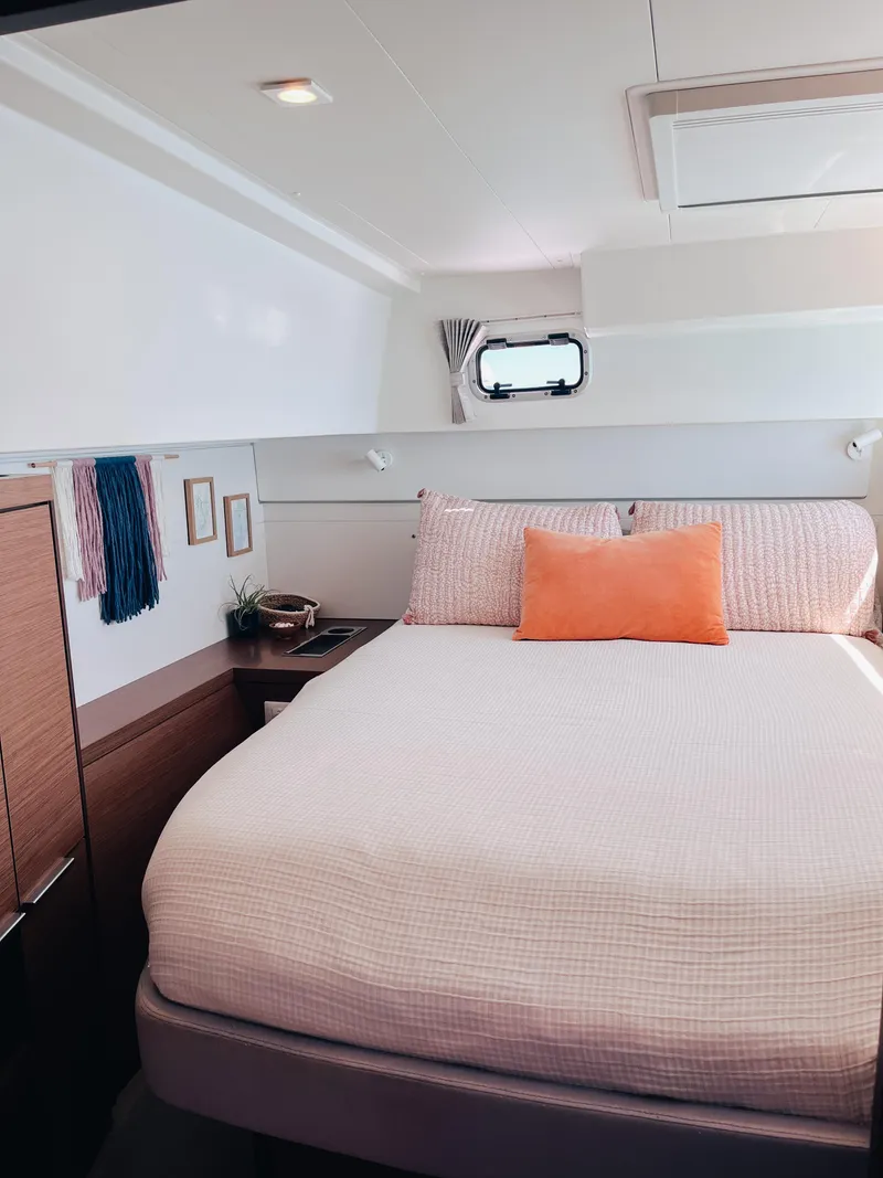 Slide: The Image of 2023 Lagoon 40 yacht cabin with cozy bed, modern decor, and natural light. - 29