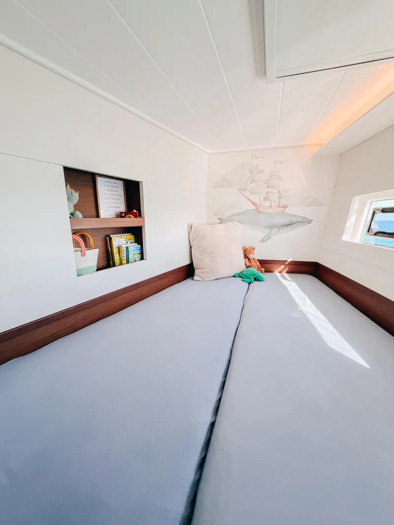 Slide: The Image of 2023 Lagoon 40 cabin interior with cozy bed, shelf, and nautical decor. - 33