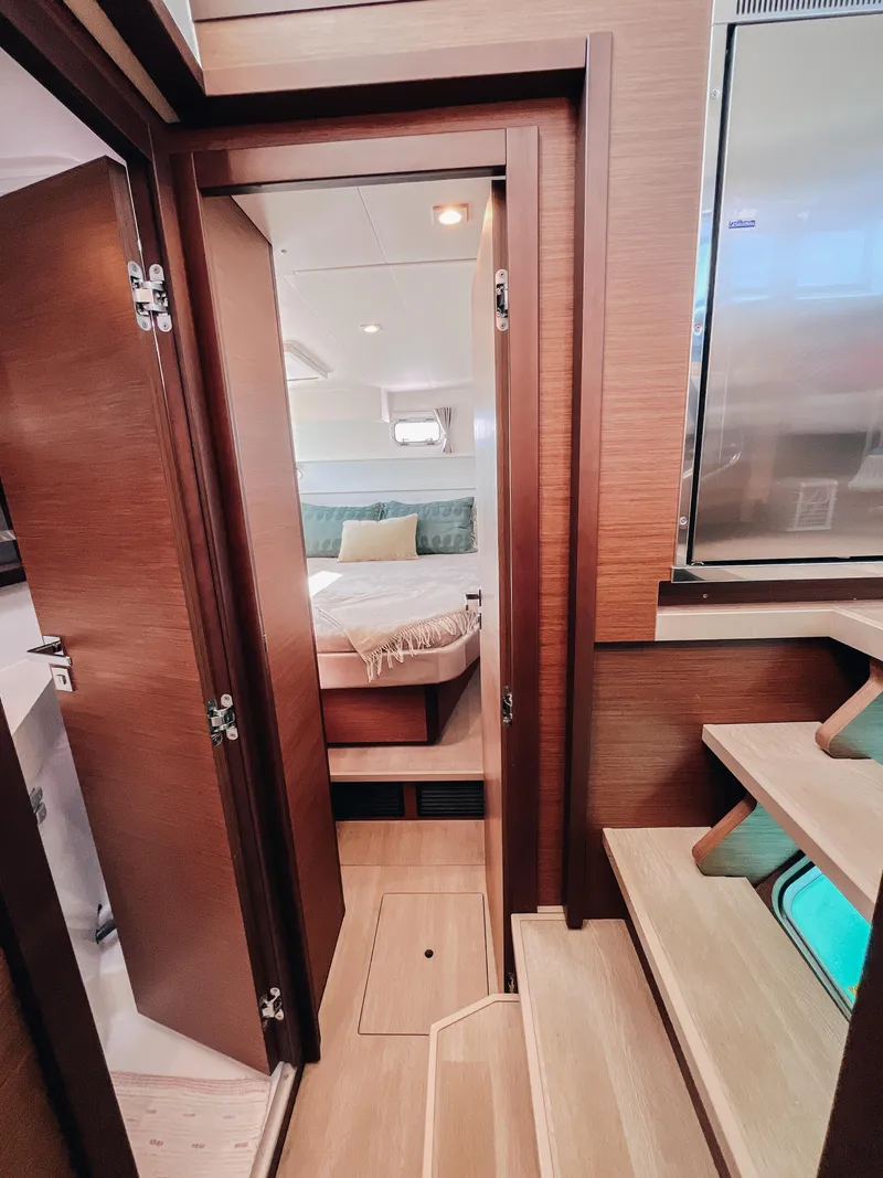 Slide: The Image of Interior of 2023 Lagoon 40 yacht showing cozy bedroom and wooden stairs. - 38