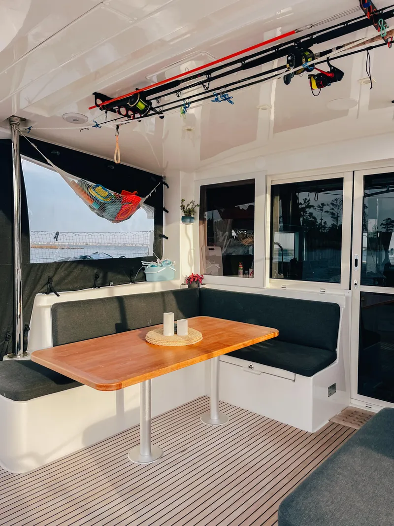 Slide: The Image of 2023 Lagoon 40 yacht interior with seating, table, and fishing rods. - 8