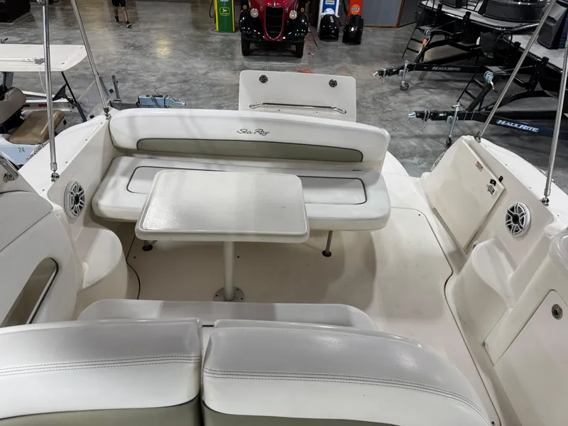 Slide: The Image of 2005 Sea Ray 300 Sundancer boat interior with seating and table in a showroom. - 10