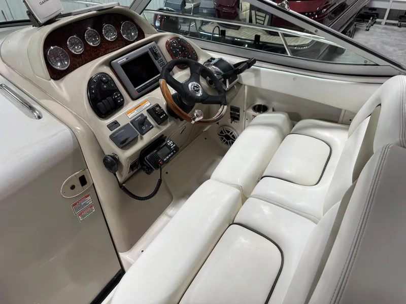 Slide: The Image of 2005 Sea Ray 300 Sundancer helm with white seating and modern navigation instruments. - 12