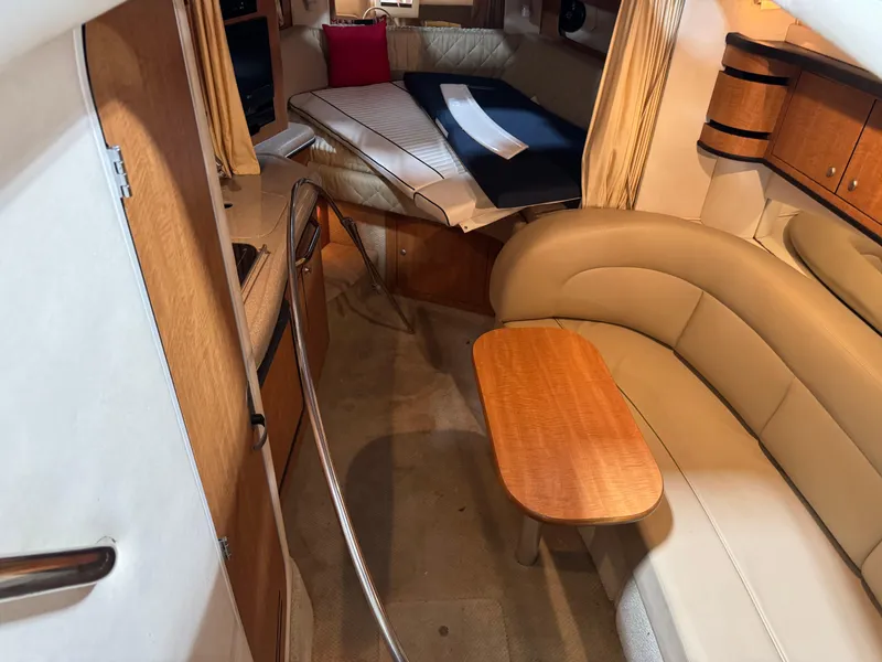 Slide: The Image of Interior of 2005 Sea Ray 300 Sundancer with beige seating and wooden table. - 13