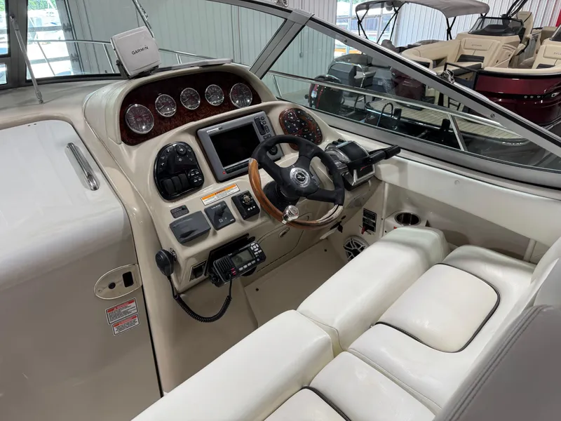 Slide: The Image of 2005 Sea Ray 300 Sundancer helm with Garmin navigation, steering wheel, and control panel. - 7