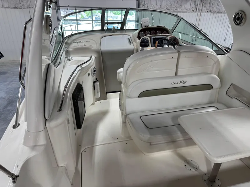 Slide: The Image of 2005 Sea Ray 300 Sundancer interior with helm, seating, and table in a bright cabin. - 8