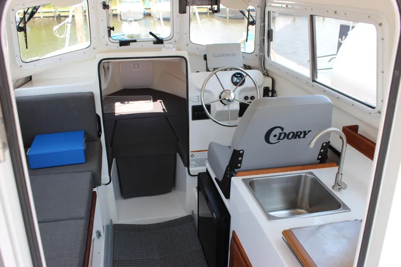 Slide: The Image of Interior of 2023 C-Dory 22' Cruiser with steering wheel, seating, and sink. - 12