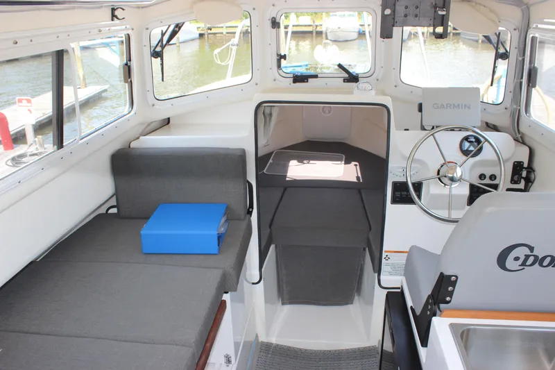 Slide: The Image of 2023 C-Dory 22' Cruiser interior with steering wheel, seating, and navigation equipment. - 14