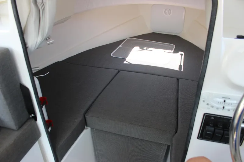 Slide: The Image of 2023 C-Dory 22' Cruiser interior cabin with gray cushions and control panel. - 17