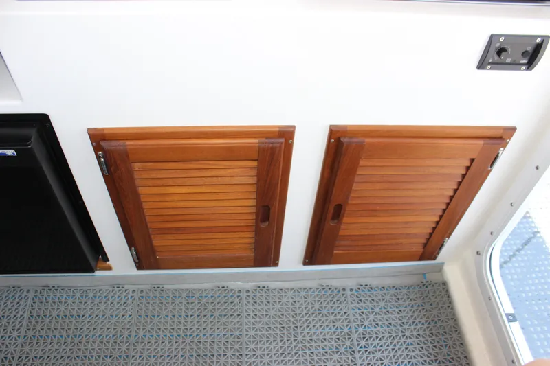 Slide: The Image of Wooden cabinet doors inside 2023 C-Dory 22' Cruiser boat interior. - 20