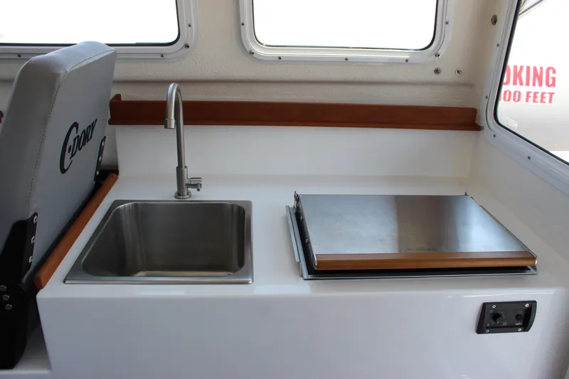 Slide: The Image of Interior of 2023 C-Dory 22' Cruiser with sink and stove in cabin. - 21