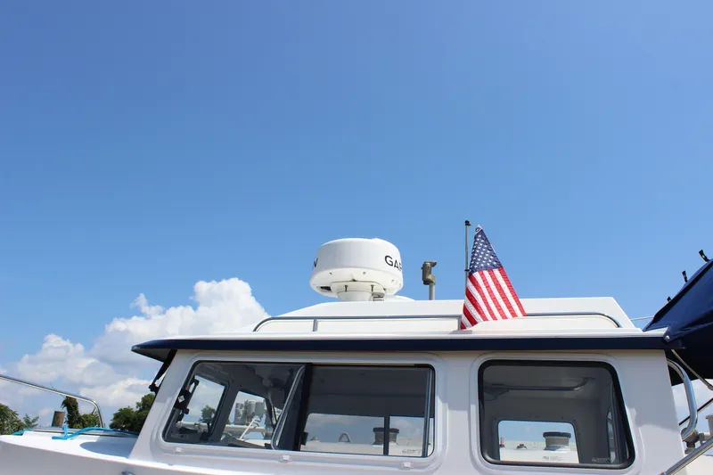 Slide: The Image of 2023 C-Dory 22' Cruiser with American flag under clear blue sky. - 23