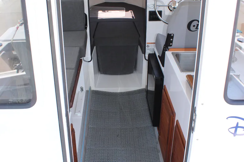 Slide: The Image of 2023 C-Dory 22' Cruiser interior with seating, steering wheel, and sink. - 24