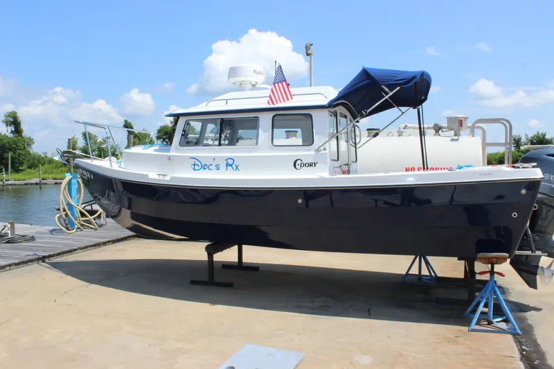 Slide: The Image of 2023 C-Dory 22' Cruiser boat on stand, dockside, with American flag. - 4