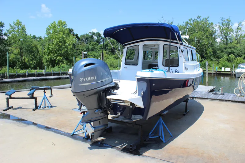 Slide: The Image of 2023 C-Dory 22' Cruiser with Yamaha motor on a dock, surrounded by greenery. - 7