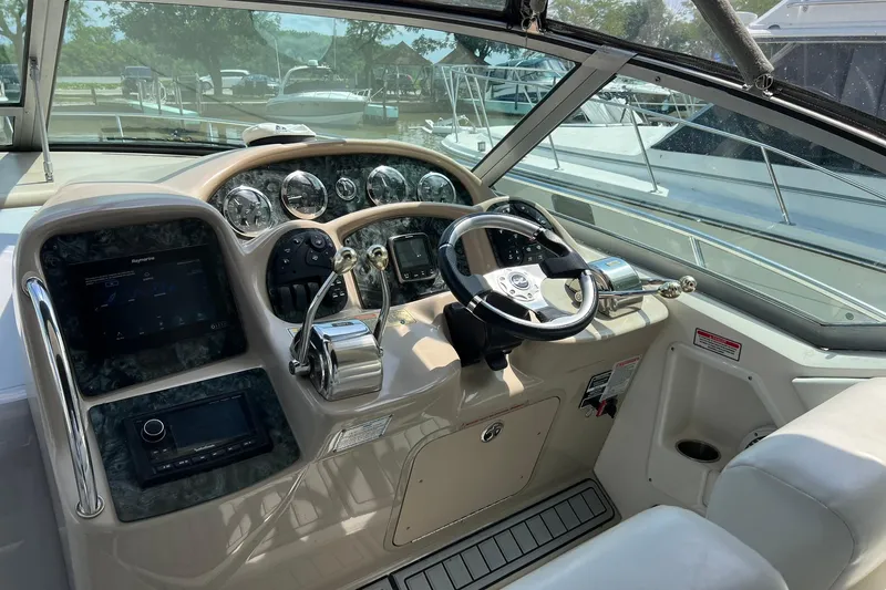 Slide: The Image of Cockpit of 2003 Sea Ray 320 Sundancer with steering wheel and control panel. - 11