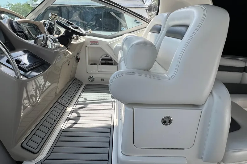 Slide: The Image of 2003 Sea Ray 320 Sundancer helm with white seating and modern controls. - 14