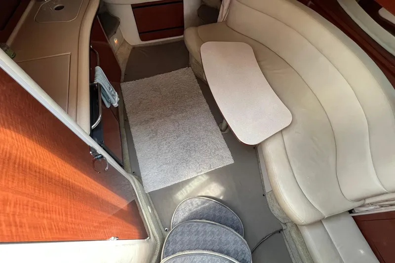 Slide: The Image of Interior of 2003 Sea Ray 320 Sundancer with beige seating and compact table. - 15