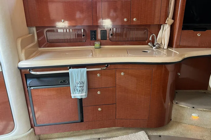 Slide: The Image of Interior of a 2003 Sea Ray 320 Sundancer yacht kitchen with wood cabinetry and sink. - 18