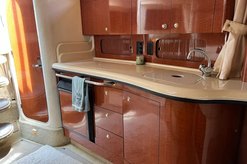 Slide: The Image of Luxurious 2003 Sea Ray 320 Sundancer yacht interior with elegant wood cabinetry and modern amenities. - 21