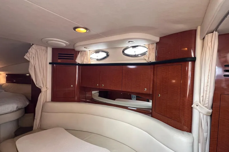 Slide: The Image of Interior of 2003 Sea Ray 320 Sundancer with wood cabinets and cream seating. - 26