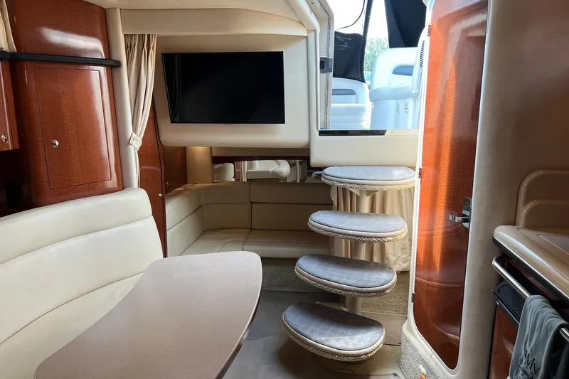 Slide: The Image of Interior of 2003 Sea Ray 320 Sundancer yacht with seating, table, and steps. - 27