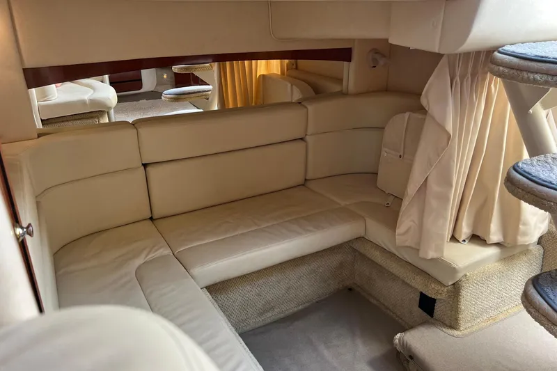 Slide: The Image of Interior of 2003 Sea Ray 320 Sundancer with beige leather seating and cozy cabin space. - 29
