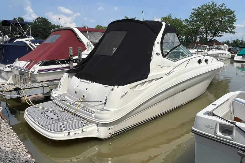 Slide: The Image of 2003 Sea Ray 320 Sundancer docked at marina, featuring sleek design and black canopy. - 3