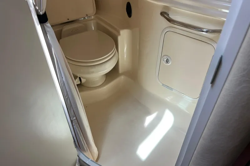 Slide: The Image of 2003 Sea Ray 320 Sundancer bathroom with toilet and storage compartment. - 31