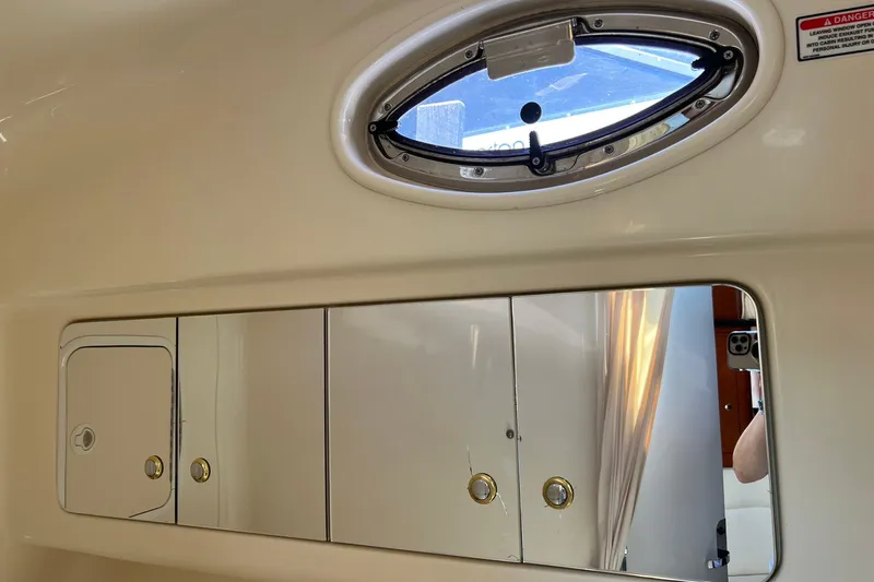 Slide: The Image of Interior of 2003 Sea Ray 320 Sundancer with porthole and mirrored cabinet. - 33