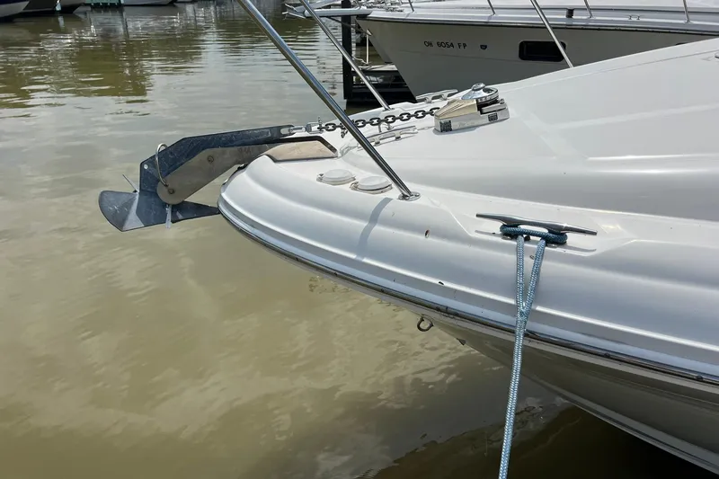 Slide: The Image of 2003 Sea Ray 320 Sundancer boat anchored at a marina, showing bow and anchor details. - 37