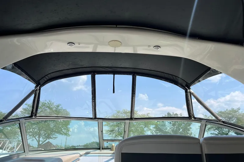 Slide: The Image of Interior view of 2003 Sea Ray 320 Sundancer boat with clear canopy and blue sky. - 9