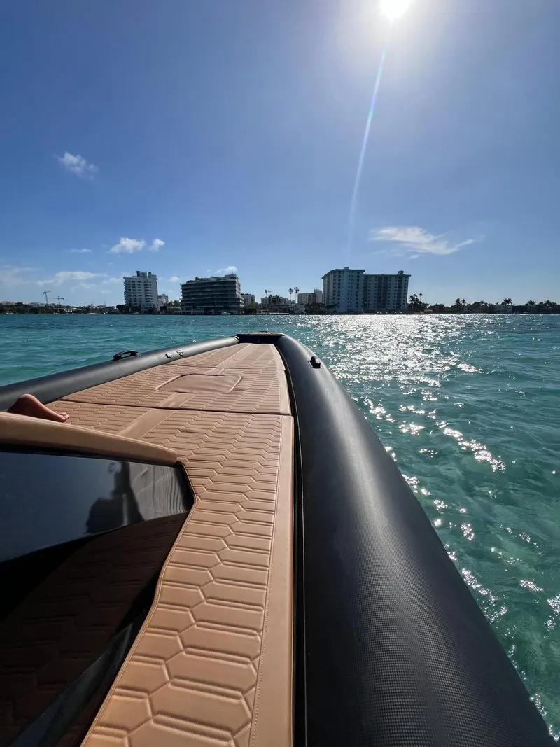 Slide: The Image of Novielli Veloche 349 boat cruising on sunny waters near city skyline, 2026 model. - 16