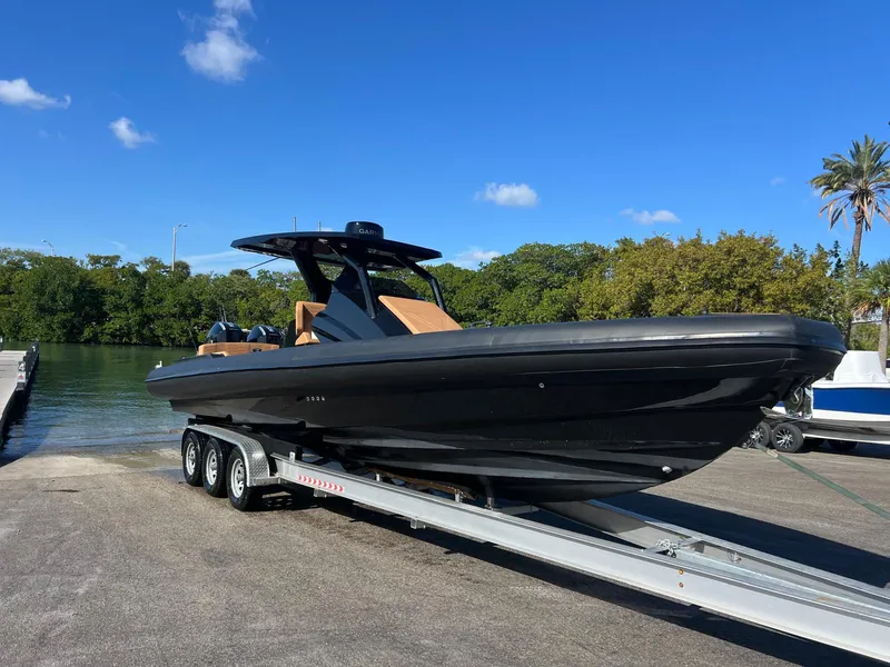 Slide: The Image of 2026 Novielli Veloche 349 boat on trailer, sleek black design, sunny day, waterfront background. - 8