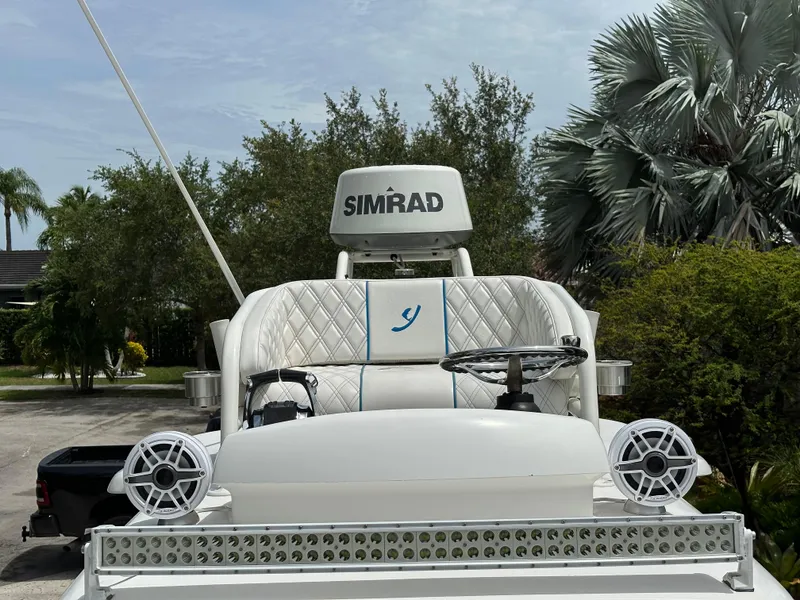 Slide: The Image of Luxury boat helm with Simrad system, Young 27 model, 2019, surrounded by lush greenery. - 12