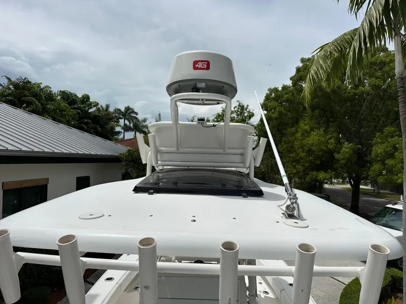 Slide: The Image of 2019 Young 27 boat with radar, antenna, and rod holders, surrounded by tropical trees. - 16