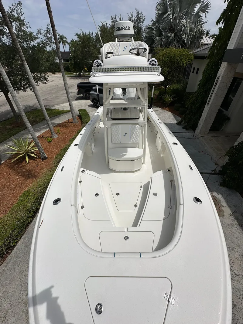 Slide: The Image of 2019 Young 27 boat with Simrad electronics, docked near palm trees. - 2