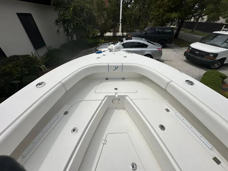 Slide: The Image of Bow view of a 2019 Young 27 boat, parked in a driveway. - 21