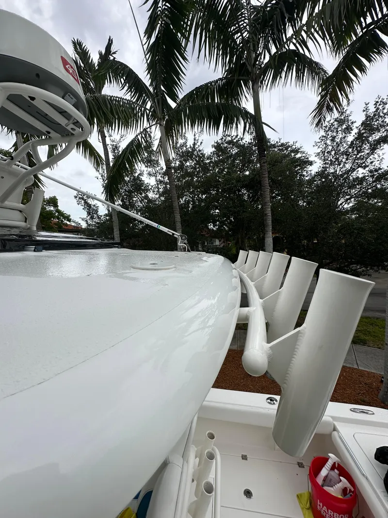 Slide: The Image of 2019 Young 27 boat with rod holders, palm trees in background. - 22