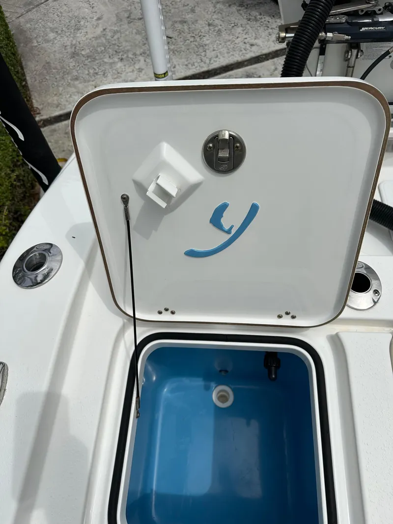 Slide: The Image of Open hatch on a 2019 Young 27 boat, revealing a blue compartment. - 34