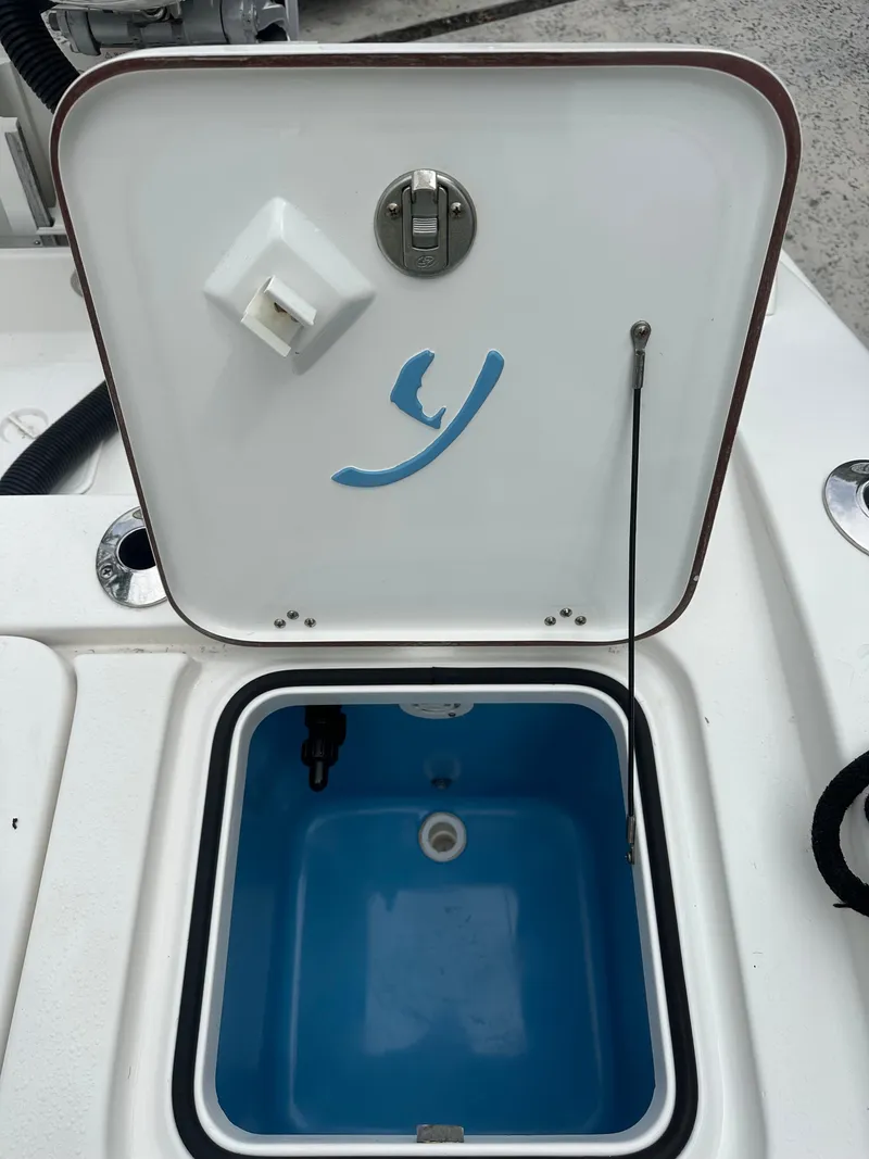 Slide: The Image of Open hatch on a 2019 Young 27 boat, revealing a blue interior compartment. - 38