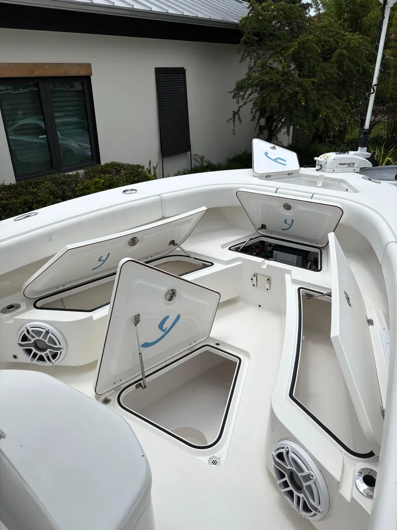 Slide: The Image of Open storage compartments on a 2019 Young 27 boat deck, featuring speakers and clean design. - 7