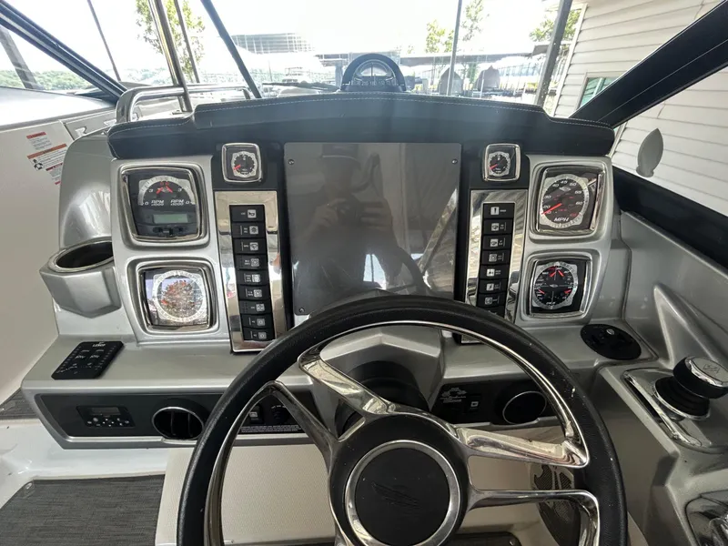 Slide: The Image of 2014 Chaparral 327 SSX boat dashboard with steering wheel and control gauges. - 10