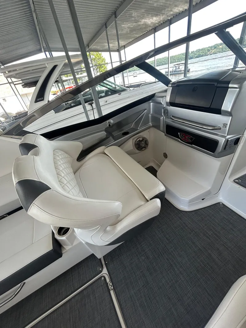 Slide: The Image of 2014 Chaparral 327 SSX boat interior with white seating and dashboard. - 11