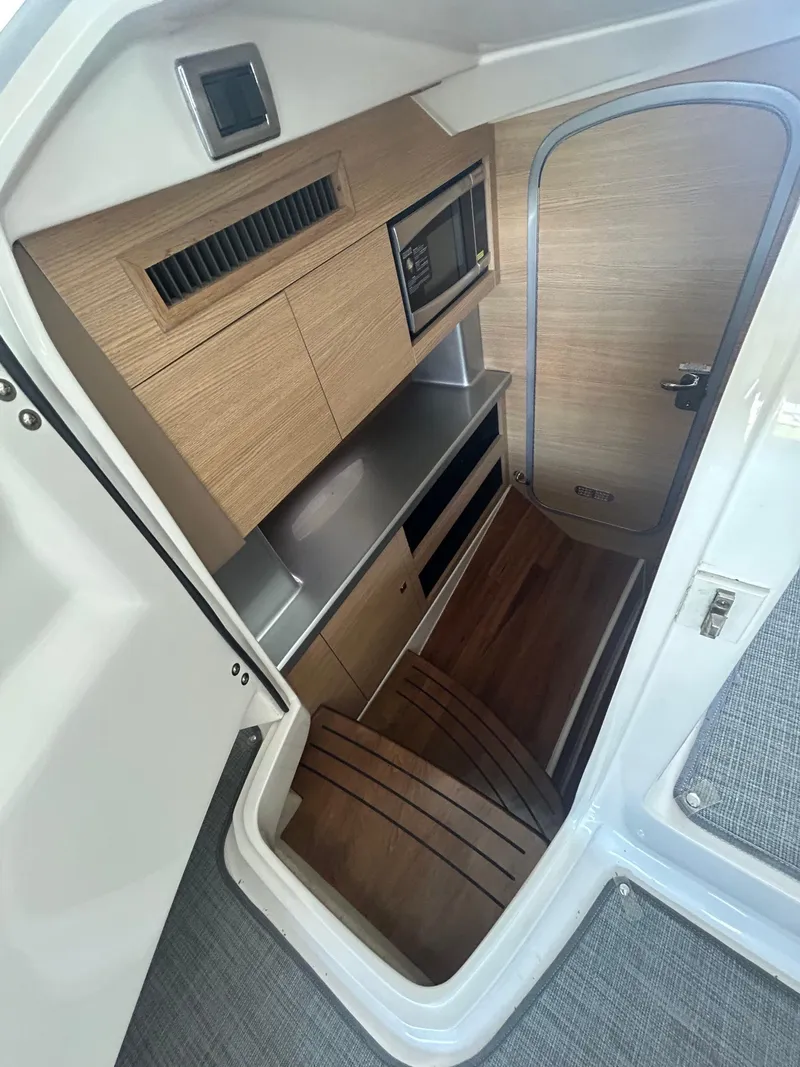 Slide: The Image of Interior cabin of 2014 Chaparral 327 SSX boat with wood finish and modern amenities. - 16