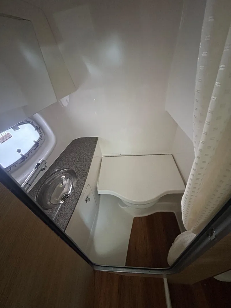 Slide: The Image of 2014 Chaparral 327 SSX boat bathroom with sink and compact toilet. - 17