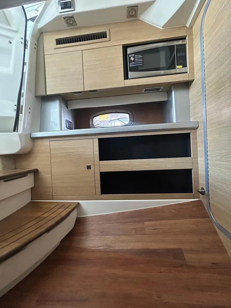 Slide: The Image of Interior of 2014 Chaparral 327 SSX boat with wooden cabinetry and microwave. - 19