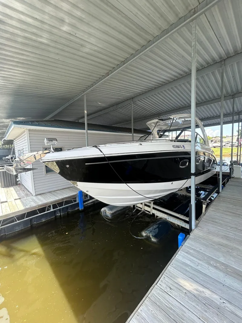 Slide: The Image of 2014 Chaparral 327 SSX boat docked under a covered marina. - 3