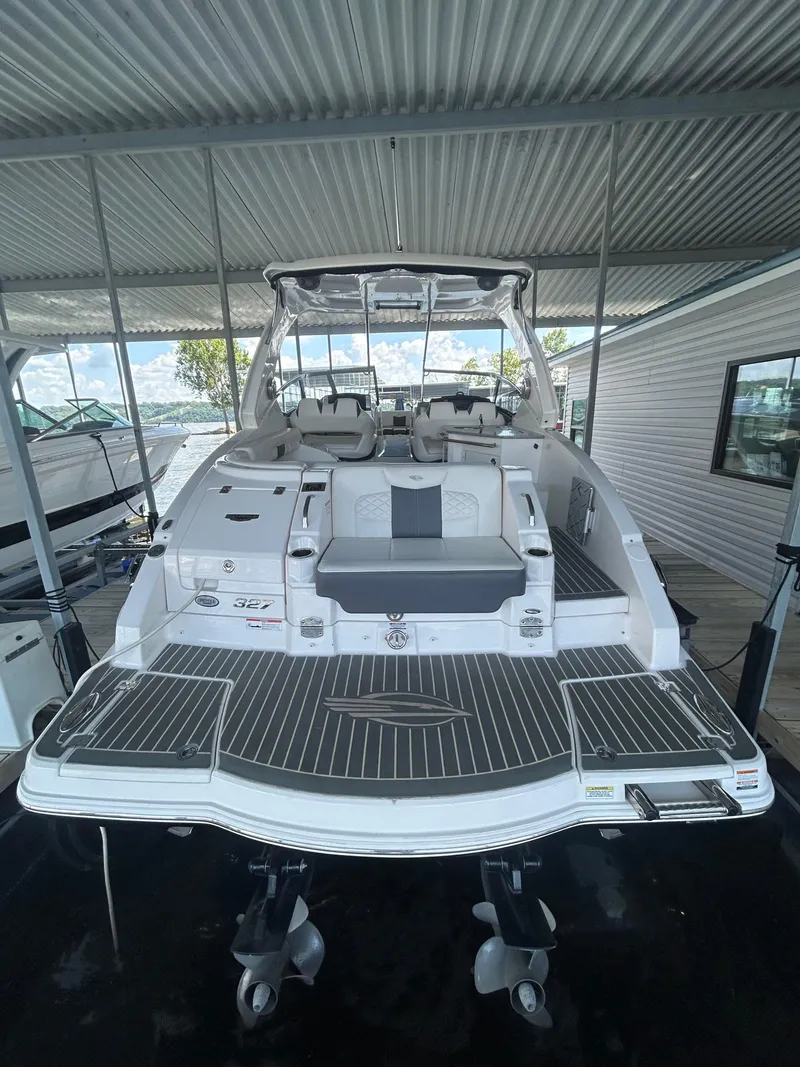 Slide: The Image of 2014 Chaparral 327 SSX boat docked under a metal canopy, rear view. - 4