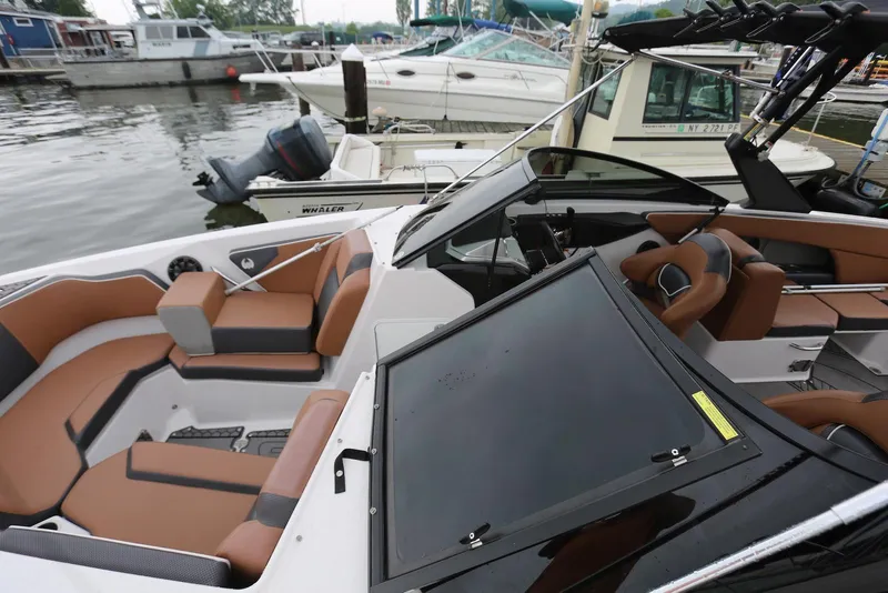 Slide: The Image of 2017 Scarab 255 Impulse boat with brown seating, docked at a marina. - 16